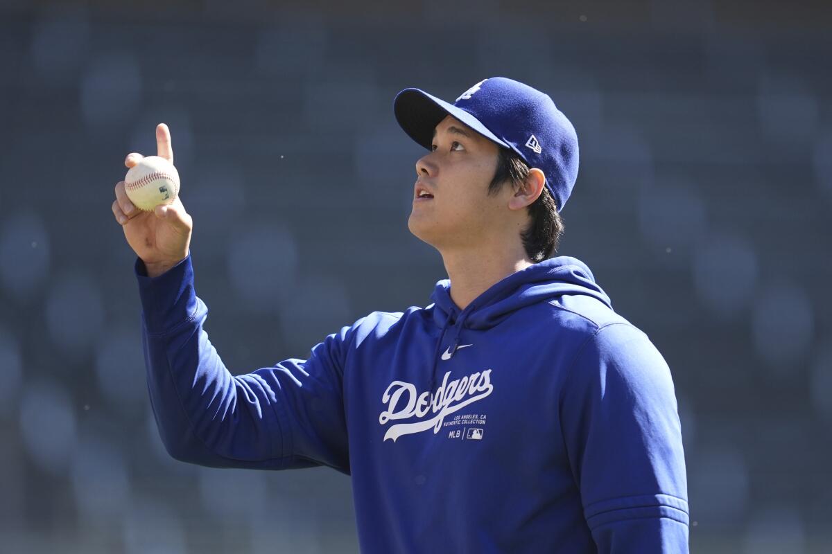 Los Angeles Dodgers' Shohei Ohtani gestures on the field before a baseball game against the