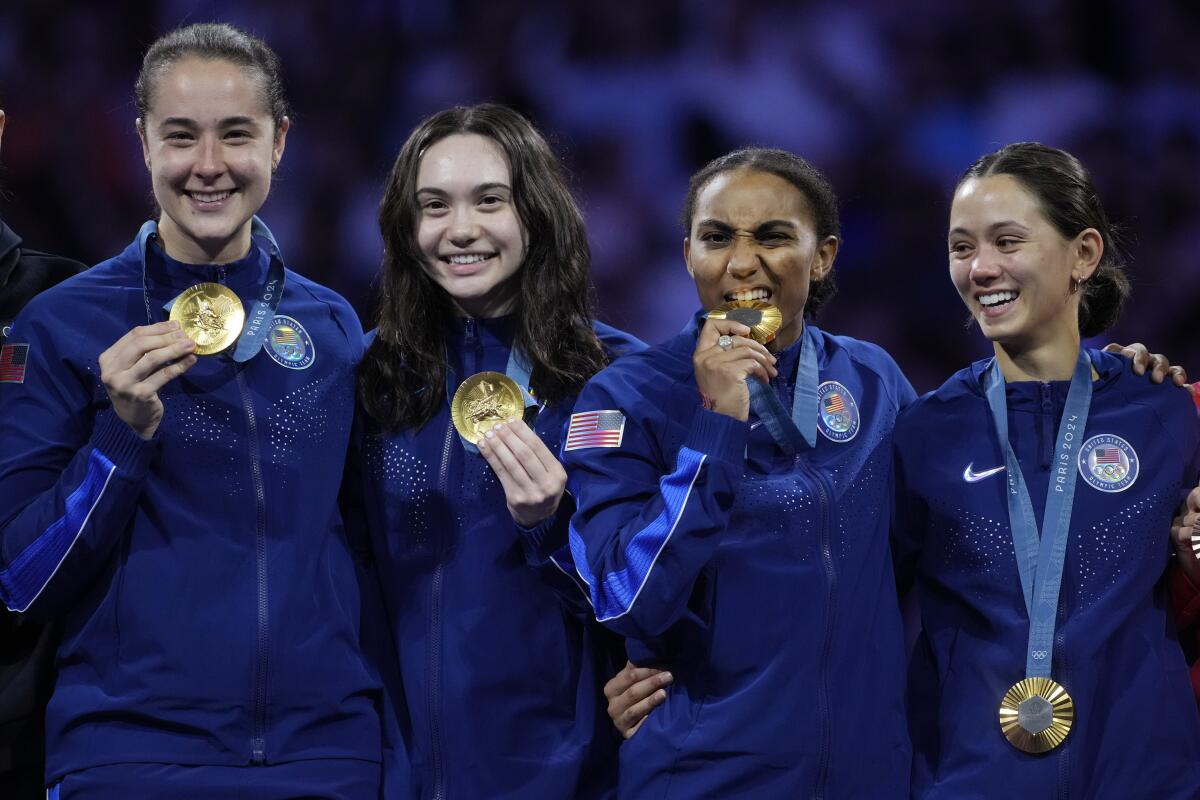 U.S. fencers Lee Kiefer, Lauren Scruggs, Jaqueline Dubrovich and Maia Mei Weintraub celebrate on the podium.