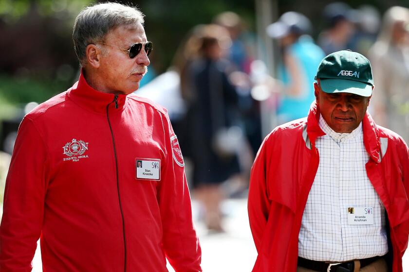 Rams owner Stan Kroenke, left, chatting with Ananda Krishnan, a Malaysian businessman and philanthropist, during a business conference, is at the forefront of NFL owners' meetings this week.