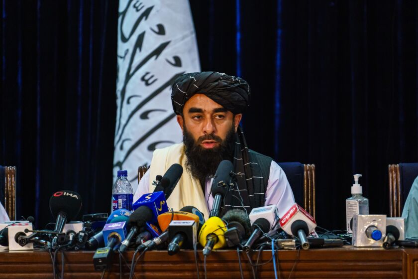 KABUL, AFGHANISTAN -- AUGUST 17, 2021: Zabihullah Mujahid, the Taliban spokesman for nearly 2 decades who worked in the shadows, makes his first-ever public appearance to address concerns about the Taliban' reputation with women's education, appearance and rights, television music and executions, during a press conference in Kabul, Afghanistan, Tuesday, Aug. 17, 2021. (MARCUS YAM / LOS ANGELES TIMES)