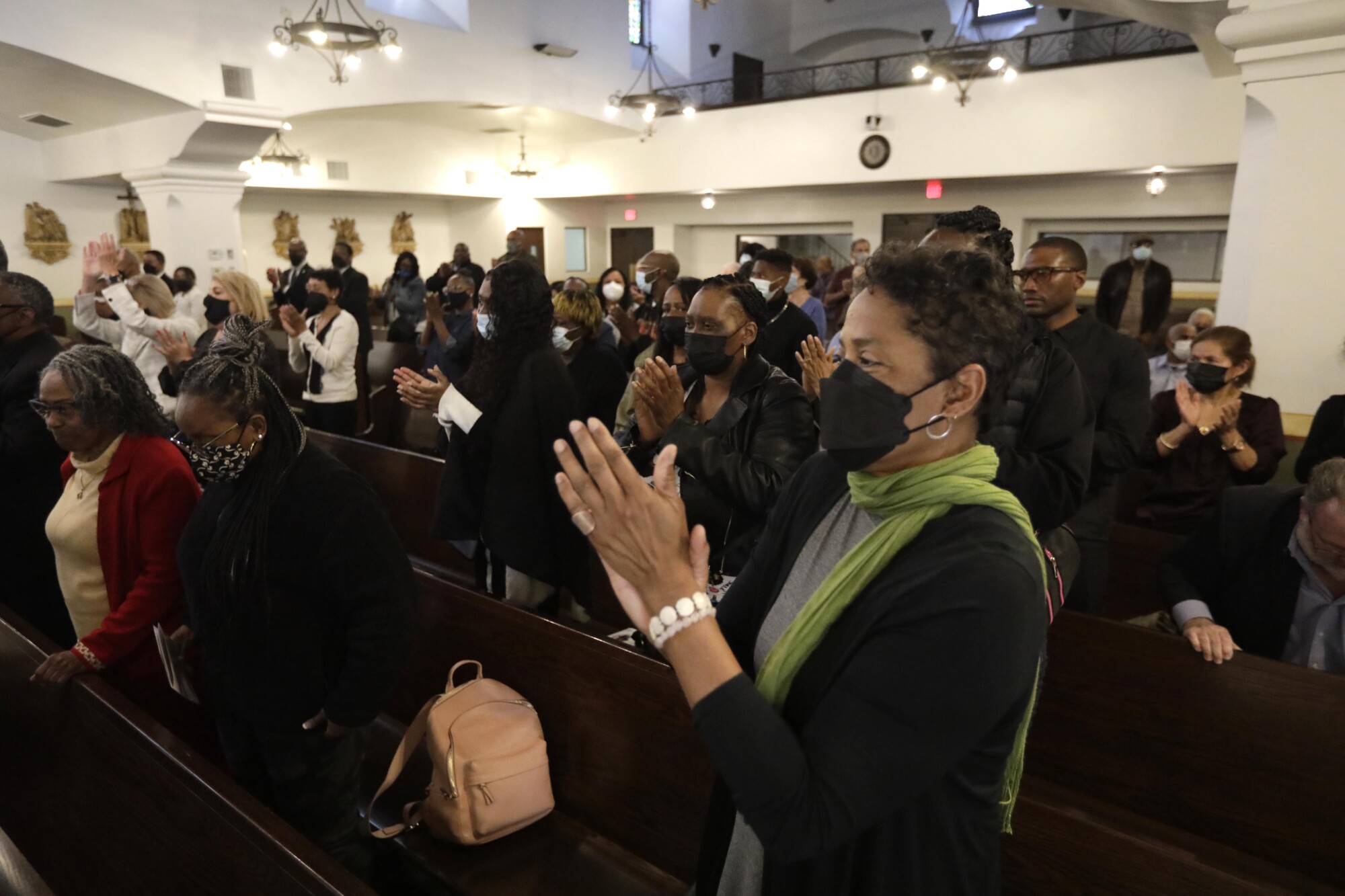Friends and family give a standing ovation in a church.