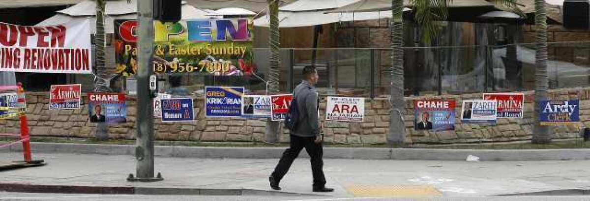 Several election signs are placed in a small strip of grass between the sidewalk and a restaurant patio on the corner of Central Avenue and Lexington Drive in Glendale.