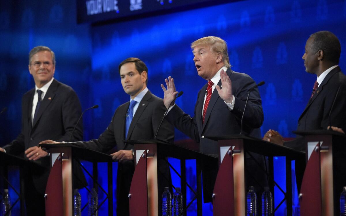 Donald Trump, second from right, speaks as Jeb Bush, left, Marco Rubio, second from left, and Ben Carson look on during the CNBC Republican presidential debate at the University of Colorado.