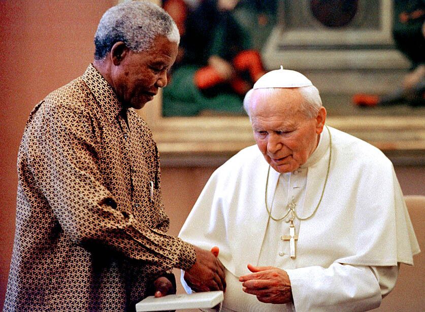 Nelson Mandela shakes the hand of Pope John Paul II during a visit by Mandela to the Vatican on June 18, 1998.
