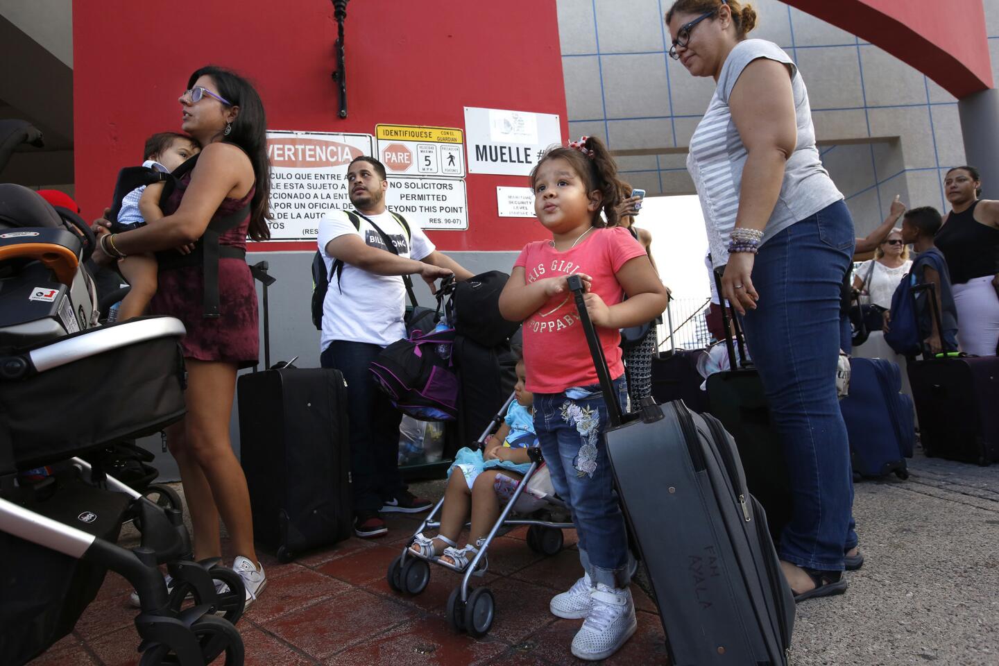 Cesar Ayala, second from left, and his family wait to board an evacuation cruise ship in San Juan.