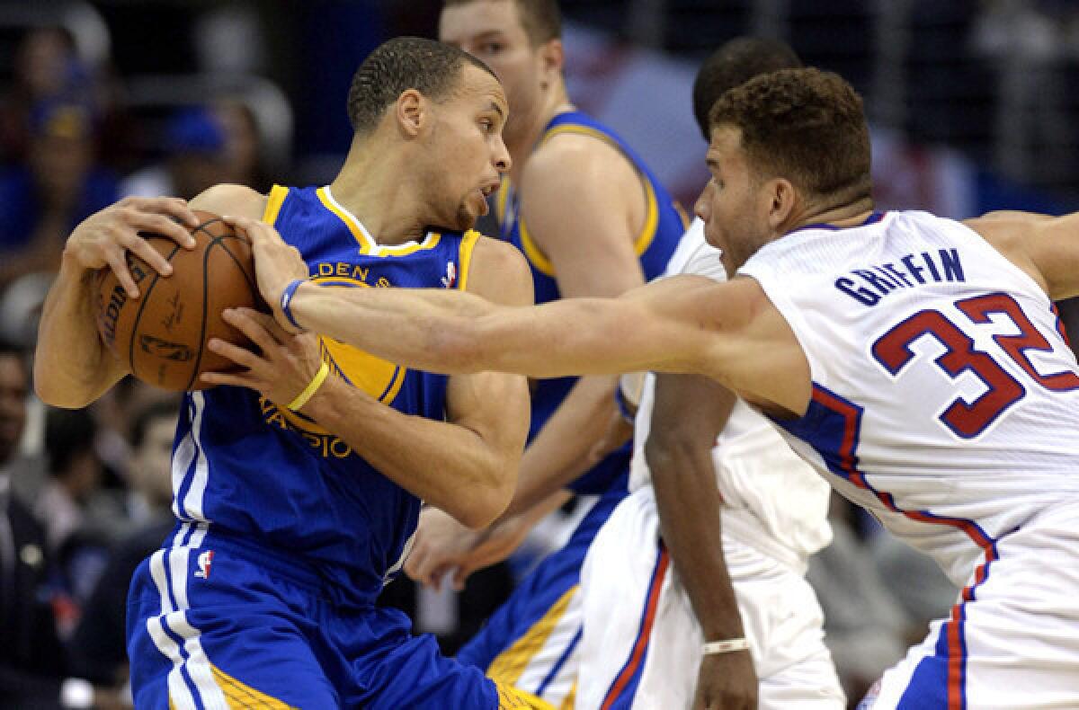 Clippers power forward Blake Griffin disrupts a pick-and-roll play for Warriors point guard Stephen Curry during a game earlier this season.