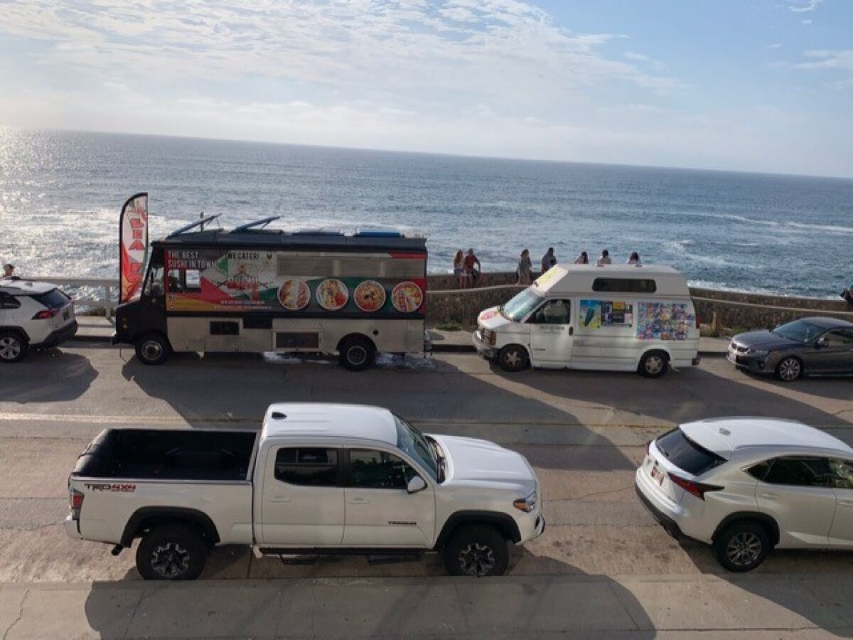 A food truck and an ice cream truck are pictured parked on Coast Boulevard near the Children's Pool in La Jolla.