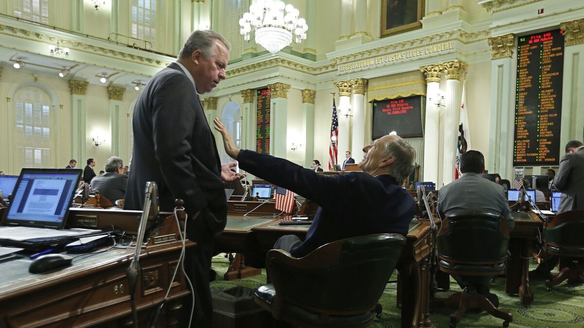 State Sen. Bill Dodd (D-Napa), left, discusses his disaster insurance bill with Assemblyman Bill Quirk (D-Hayward) on Thursday in Sacramento.