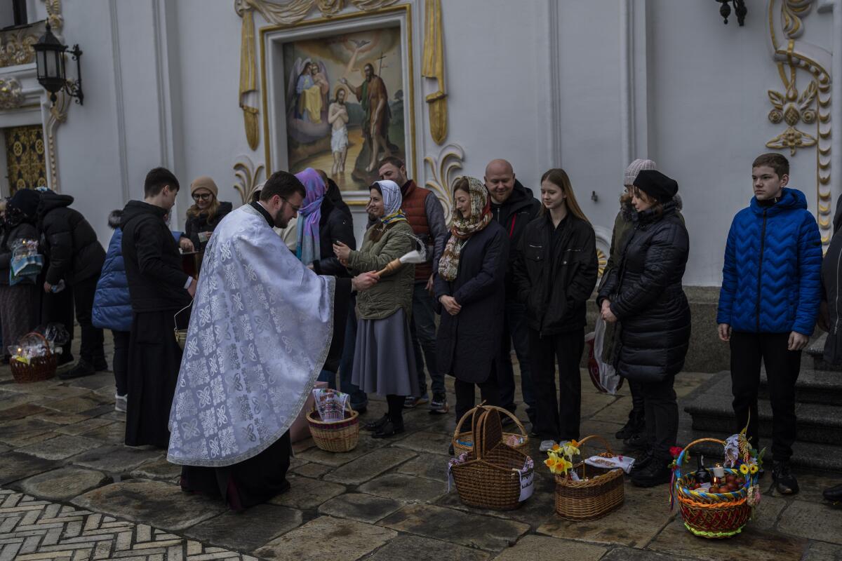 Orthodox Christian worshipers have their Easter baskets blessed by a priest at a monastic complex.