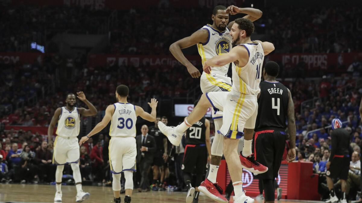 Warriors teammates Kevin Durant (35) and Klay Thompson (11) celebrate a Thompson dunk during the second quarter.