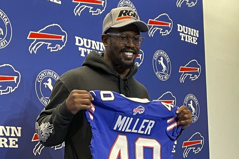 Von Miller holds up a Buffalo Bills jersey during a news conference Thursday, March 17, 2022, in Orchard Park, N.Y. Miller was introduced as the Bills' prized free-agent addition, a day after agreeing to terms on a six-year contract. (AP Photo/Mark Ludwiczak)