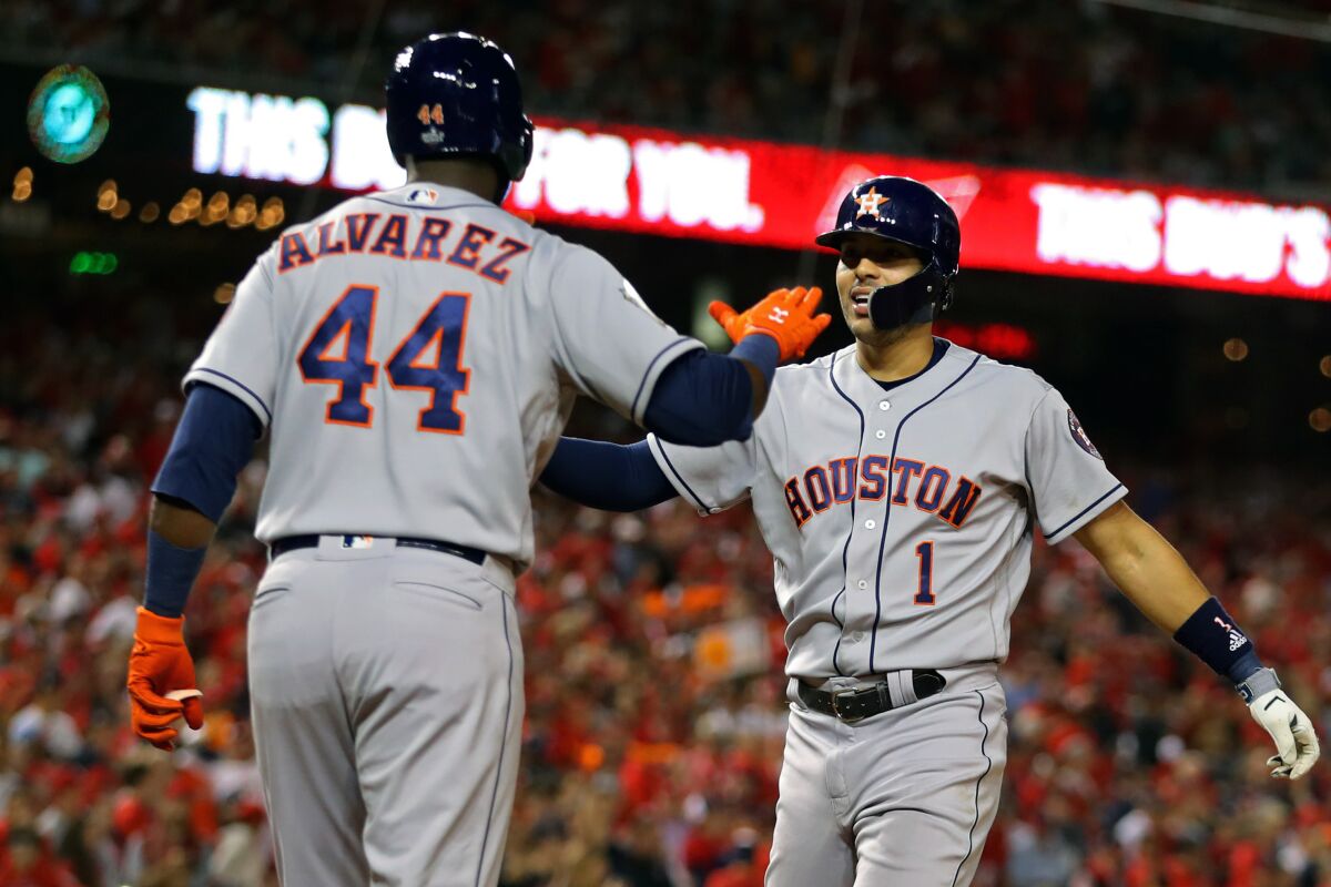 Houston Astros shortstop Carlos Correa, right, is congratulated by teammate Yordan Alvarez.