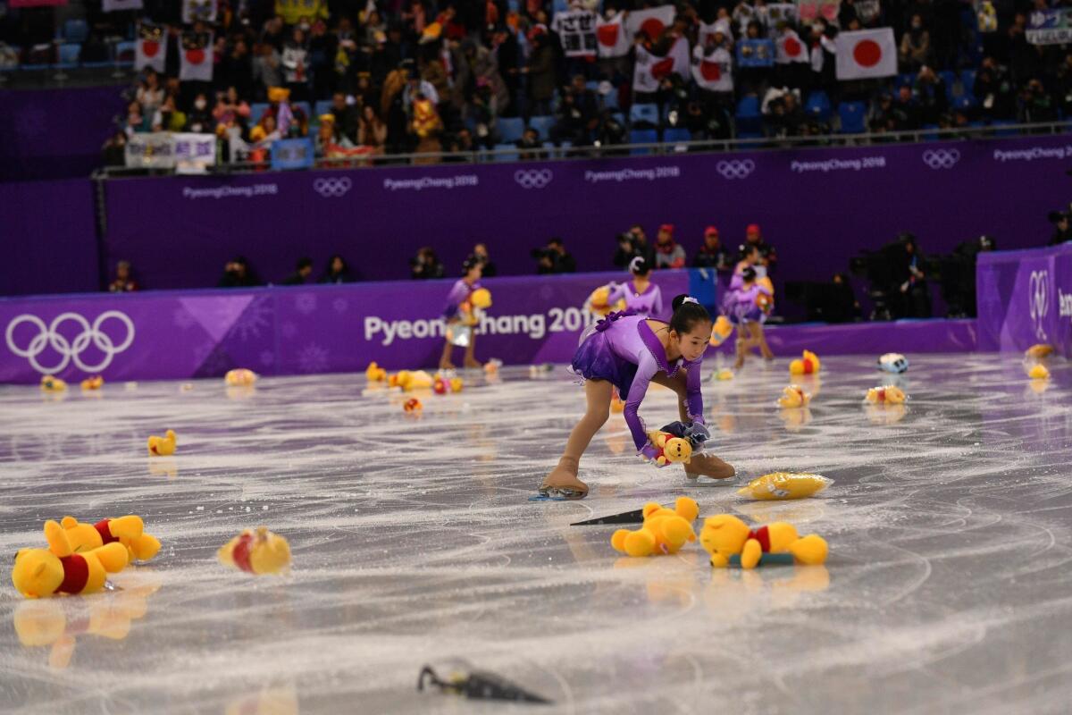 Children collect Winnie the Pooh plush toys thrown onto the rink by spectators following a performance by Japan's Yuzuru Hanyu on Feb. 16.