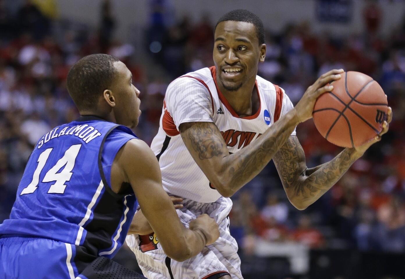 Louisville guard Kevin Ware looks to pass against the defense of Duke guard Rasheed Sulaimon in the first half of the NCAA tournament Midwest Regional final on Sunday at Lucas Oil Stadium in Indianapolis.