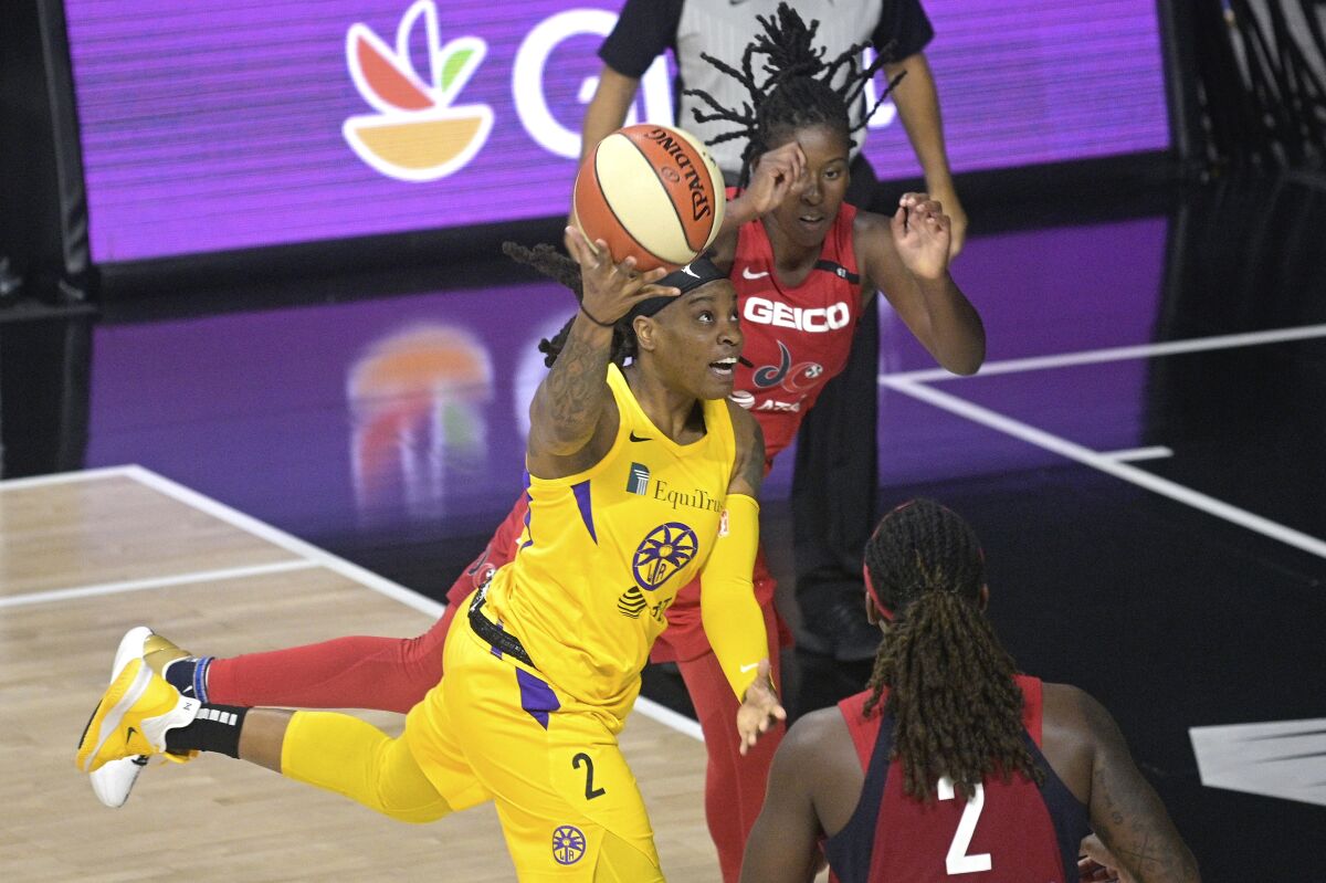 Sparks guard Riquna Williams shoots between Washington Mystics guard Ariel Atkins and forward Myisha Hines-Allen.