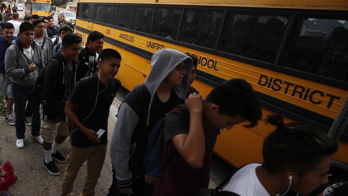 Students line up to board buses for the start of school in August this year.
