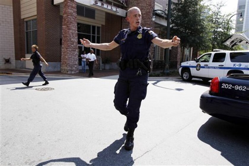 Police push people back from near the front of the headquarters of the Discovery Channel networks building in Silver Spring, Md., Wednesday Sept. 1, 2010. Police say a gunman has taken at least one person hostage in the building. (AP Photo/Jose Luis Magana)