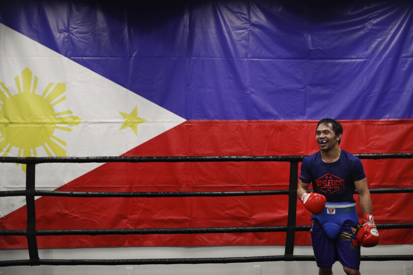 Manny Pacquiao, shown in training in 2019 in a gym with a wall-size Philippines flag