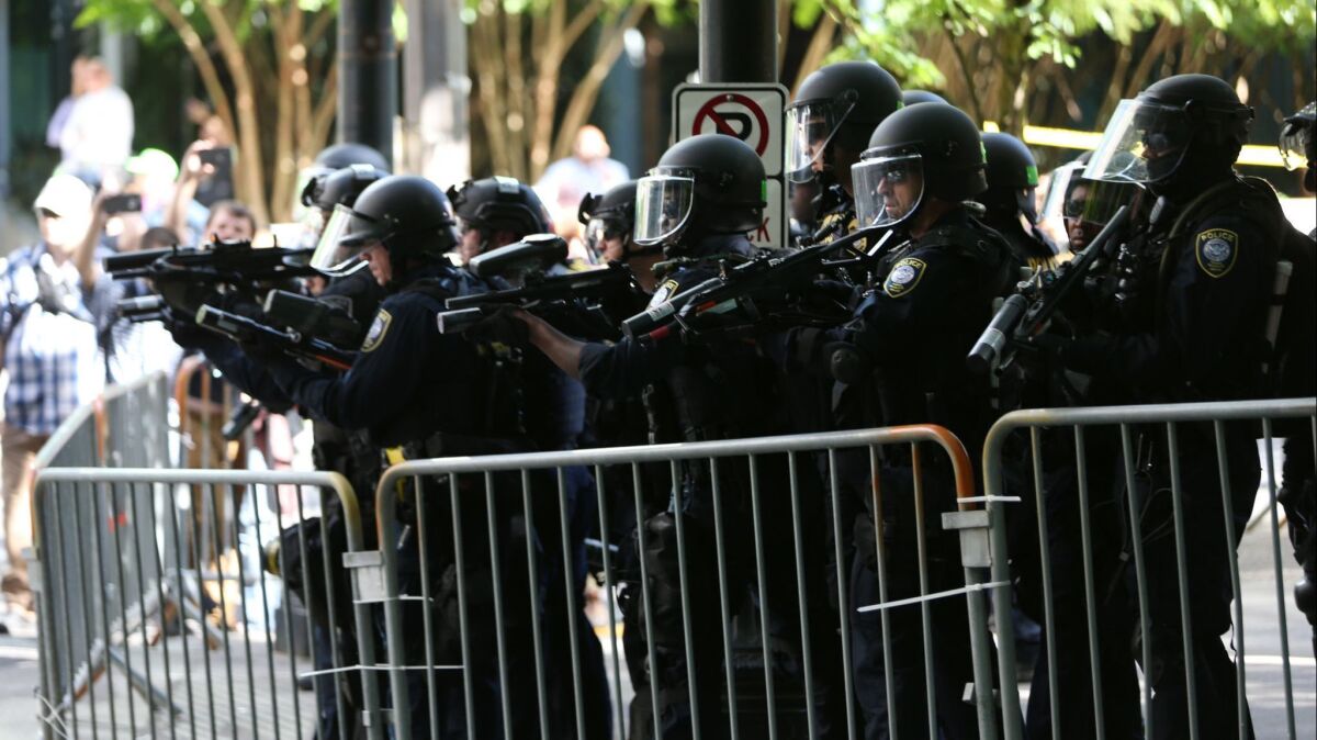 Police disperse clashing protesters after violence erupted when two opposing protest groups took to the streets in Portland, Ore.