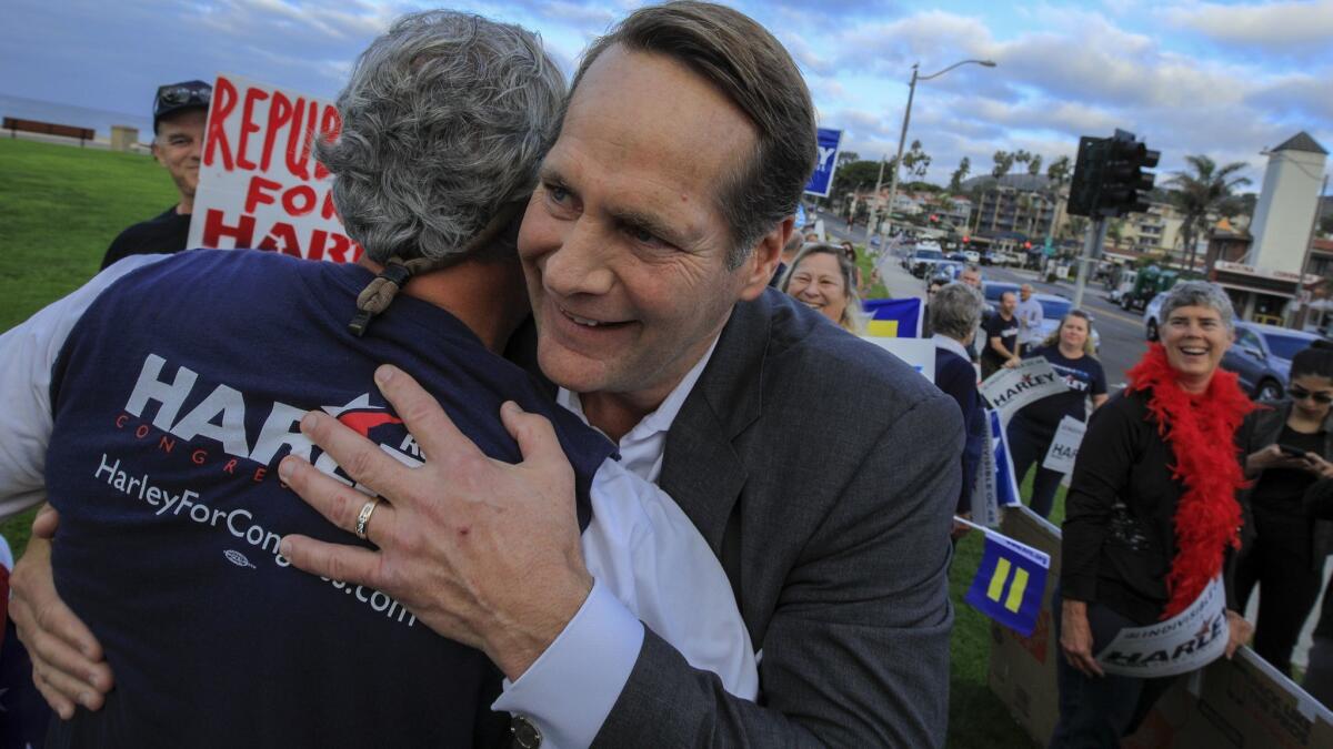 Harley Rouda, candidate for the 48th Congressional District, hugs a supporter at an election rally in Laguna Beach.