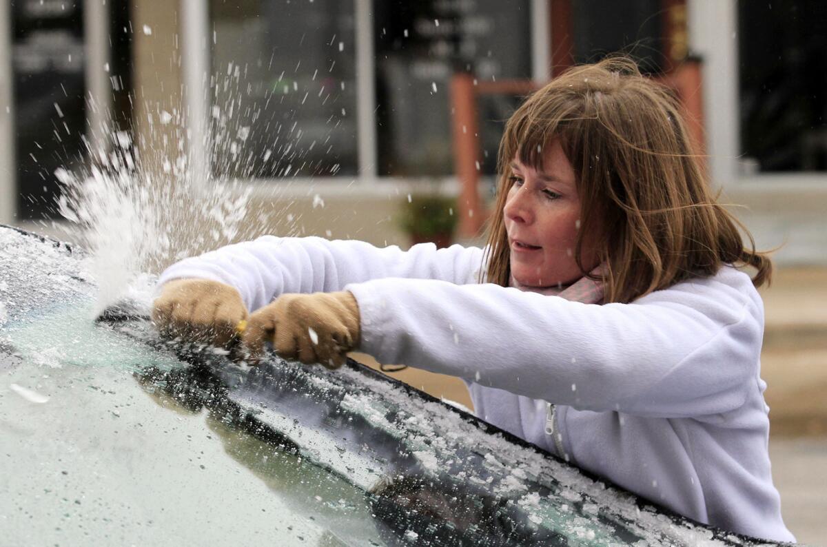 Krystal Wright retira el hielo del parabrisas de su vehículo en Wichita, Kansas, el viernes 27 de noviembre de 2015. Lluvia congelada e inundaciones efectaban el viernes Texas, Kansas y otras partes del centro de Estados Unidos.