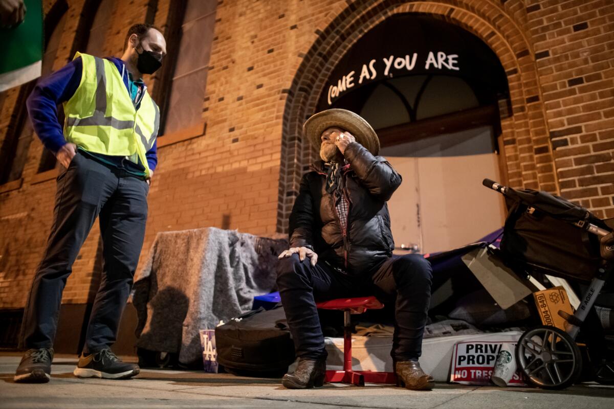 Unhoused Billy Jones speaks with volunteer Ari Hamilton in Echo Park