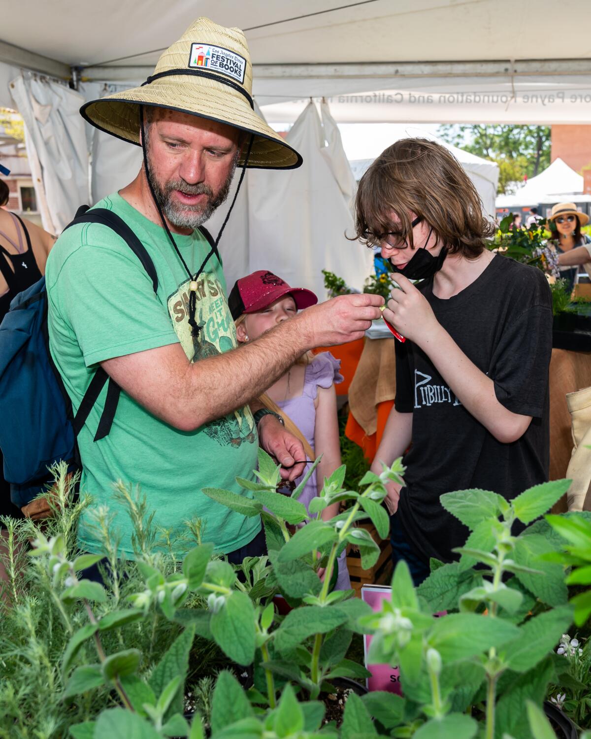 Festival of Books attendees sniff native plants at the 2023 L.A. Times Plants booth.