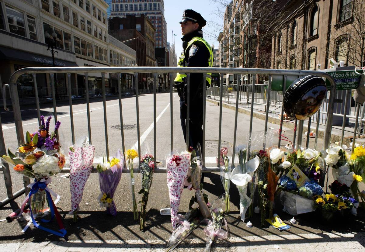 A Boston police officer stands guard at a memorial at Boylston and Arlington streets. The bombings at the Boston Marathon have brought flashbacks of 9/11 to many American Muslims — when they watched the horror in Manhattan and felt attacked as Americans, and then felt attacked for their faith.