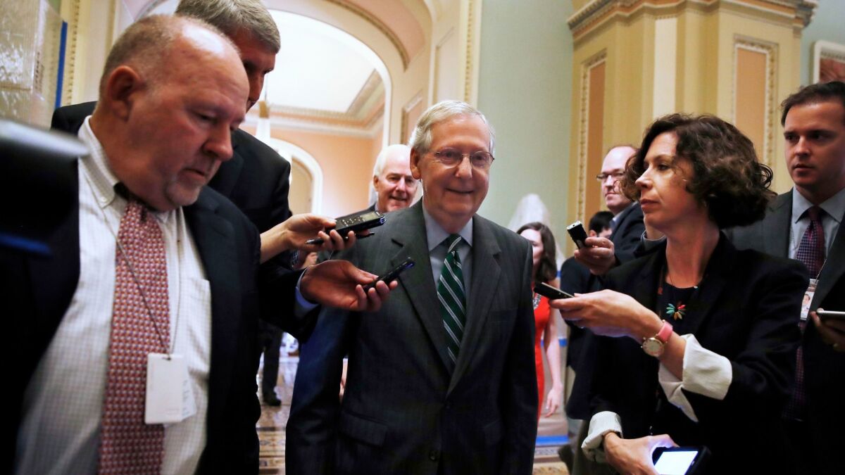 Senate Majority Leader Mitch McConnell (R-Ky.), center, leaves a Republican meeting on healthcare Thursday.