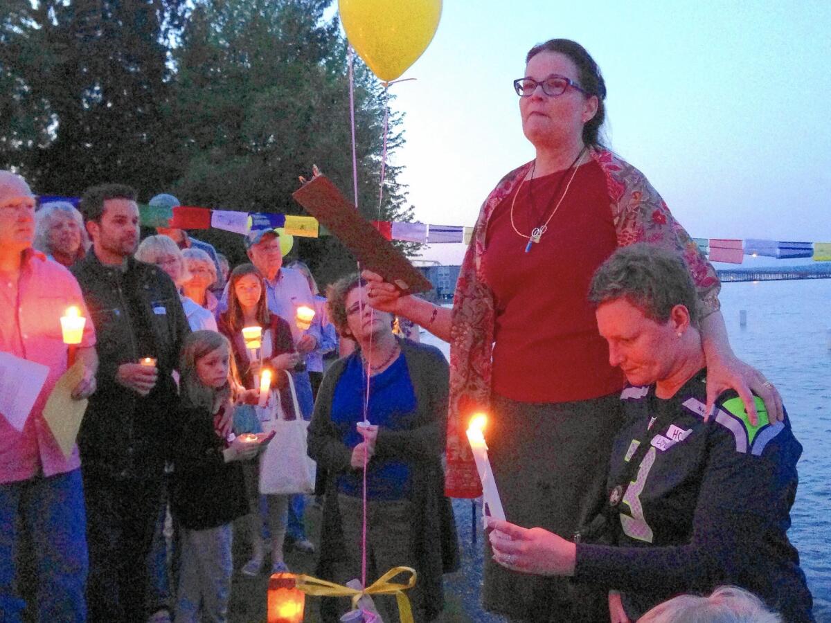 Sydney Schumacher’s mother, Diane Schumacher, standing at right, and Bailey Meola’s mother, Rochelle Brown, seated, at a Seattle vigil for the pair.