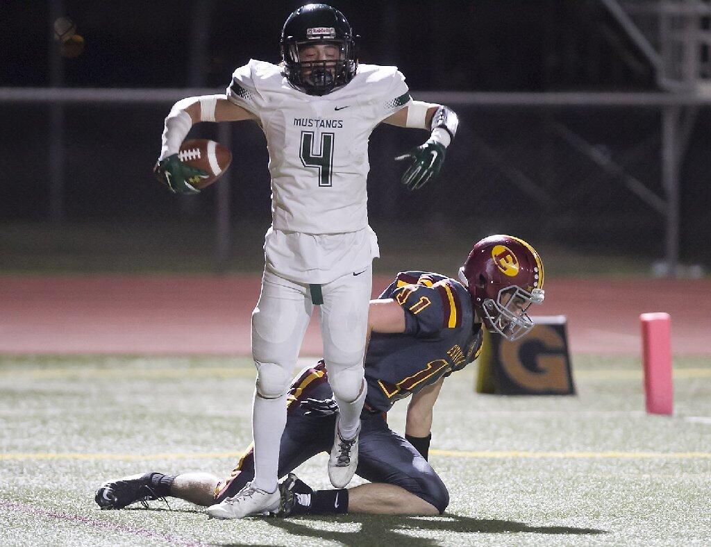 Costa Mesa High's Christian Villaverde (4) scores a touchdown against Estancia during the Battle for the Bell.