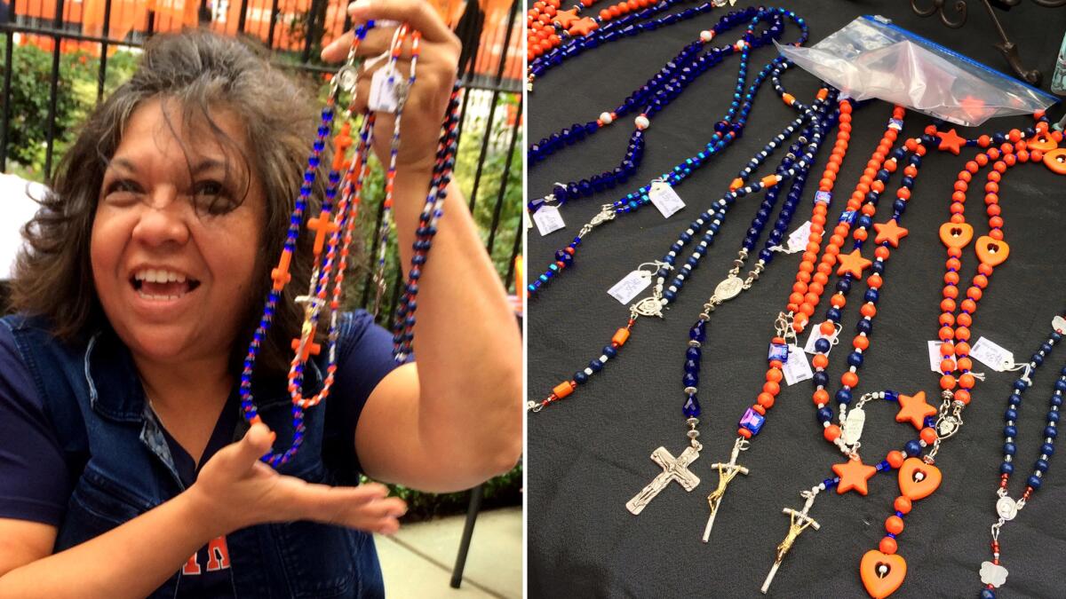 Elsie Hernandez displays the rosary beads, as well as necklaces and bracelets, that the Annunciation Church sells for Astros games.