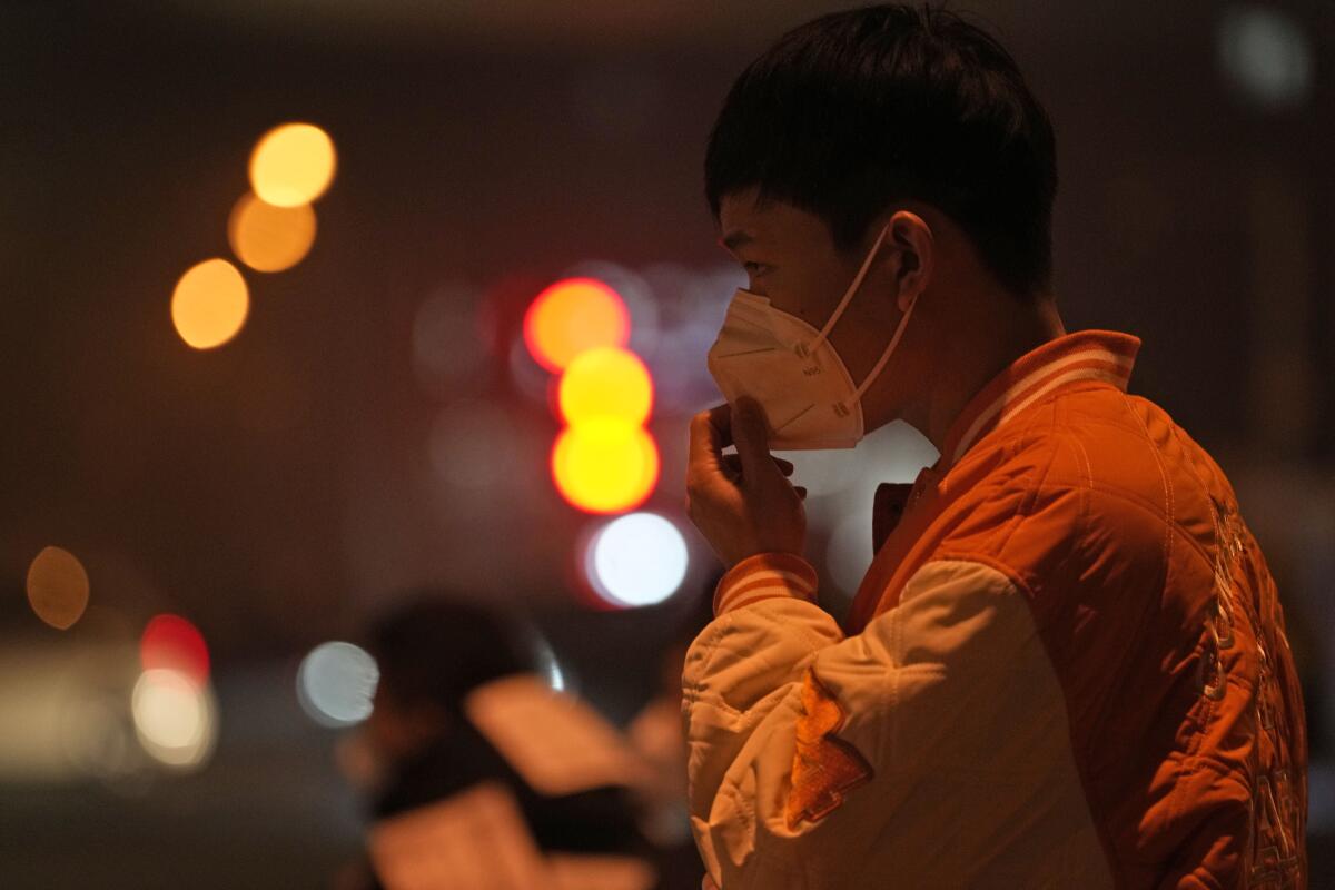 Man adjusting his mask on the street in Beijing
