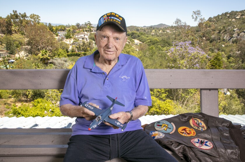 Royce Williams, 97, holds a model of the F9F-5 Panther Navy aircraft with which he flew in an air combat in the Korean War. 