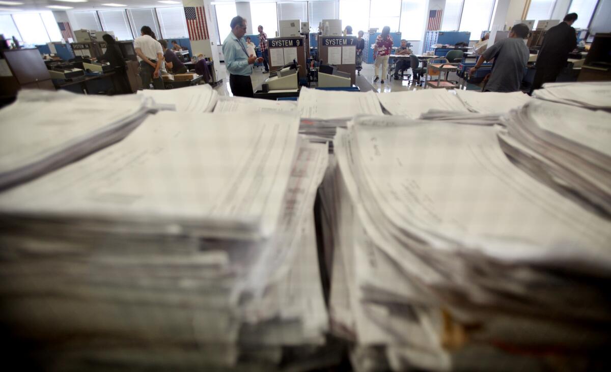 Inside a locked room, county election officials methodically load ballots into computers after election day in November 2012 at the L.A. County Registrar-Recorder's offices in Norwalk.