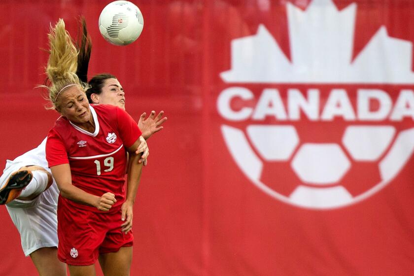 Canada's Adrianna Leon (front) and England's Claire Rafferty collide as they attempt to head the ball during an exhibition game on May 29 in Hamilton, Canada.