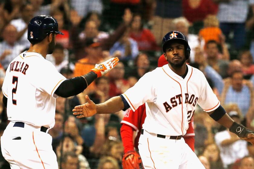 Jonathan Villar, left, and Dexter Fowler, right, celebrate after scoring two of the Astros' five runs in the third inning of the Angels' 7-2 loss to Houston.