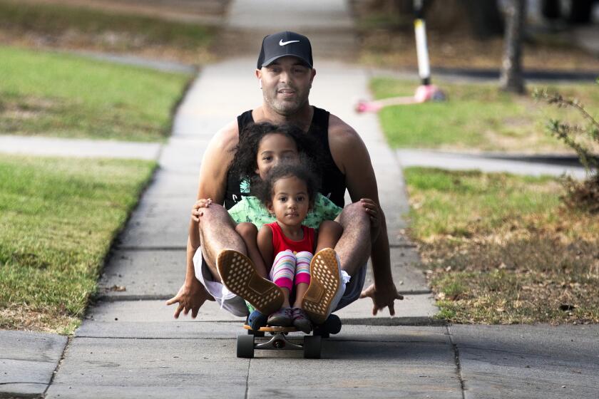 Dartagnan Molinar, 38, and his children take a ride on his skateboard.