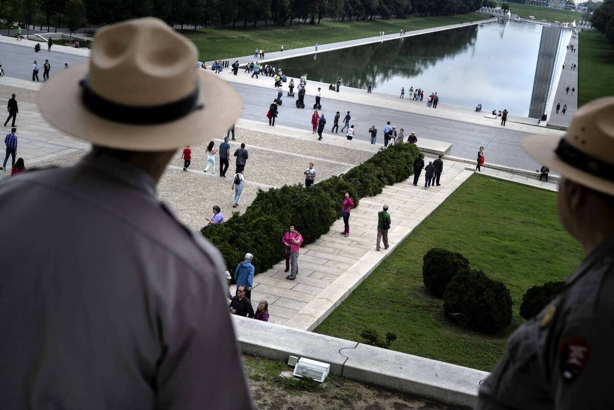Park rangers watch as visitors return to the Lincoln Memorial after the U.S. government shutdown. The crisis sparked interest in reform efforts pioneered by California to create a more moderate body of elected officials.