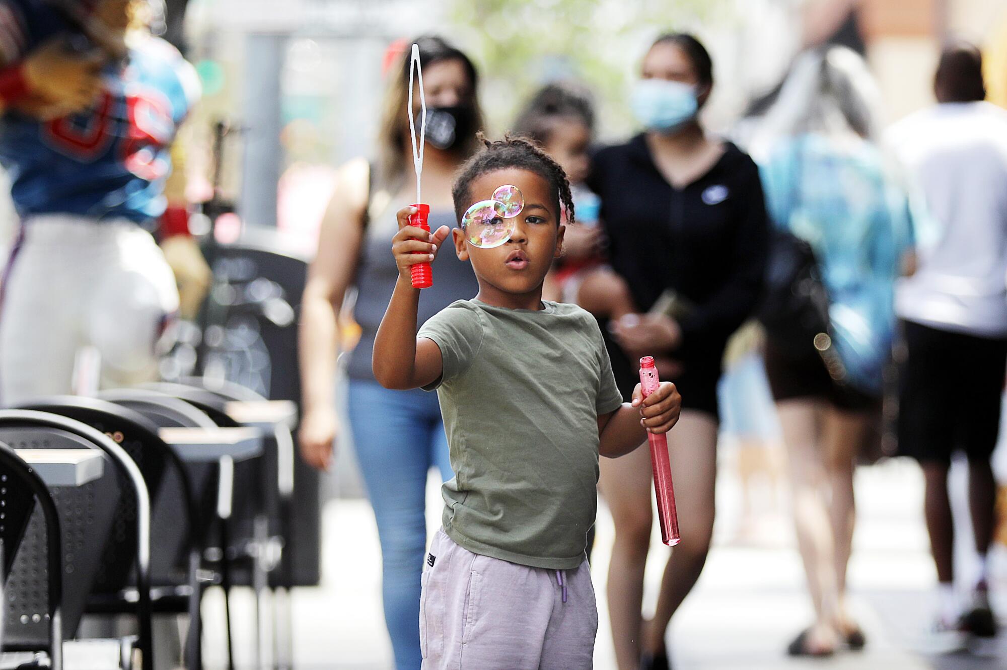 Tobias Blackmon, 6, plays with bubbles on Second Street in Belmont Shore on Tuesday, June 15, 2021.