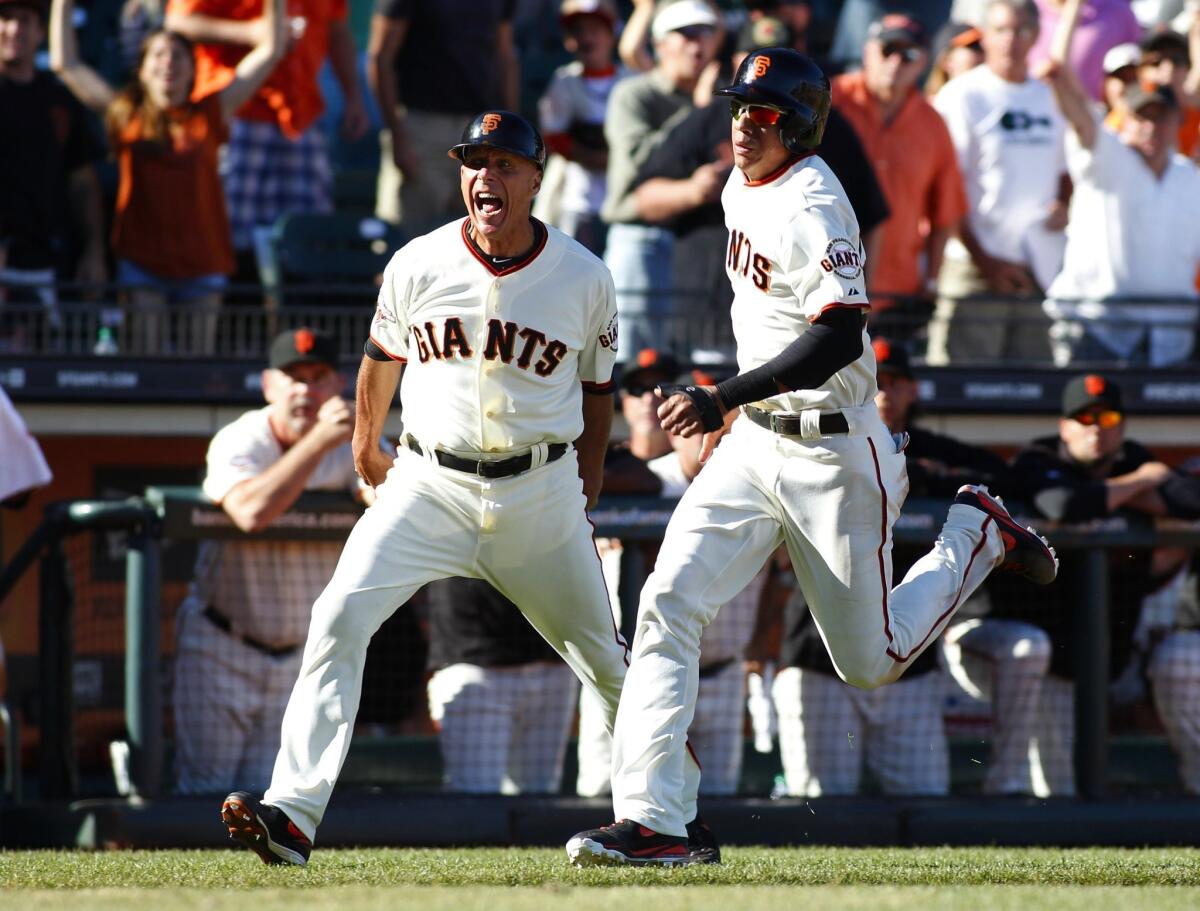 Then-San Francisco Giants third base coach Tim Flannery yells as Ehire Adrianza heads home during the 11th inning against Arizona on Sept. 8, 2013.