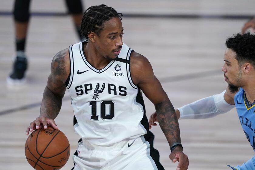 San Antonio Spurs' DeMar DeRozan (10) dribbles up the court against Memphis Grizzlies' Dillon Brooks.