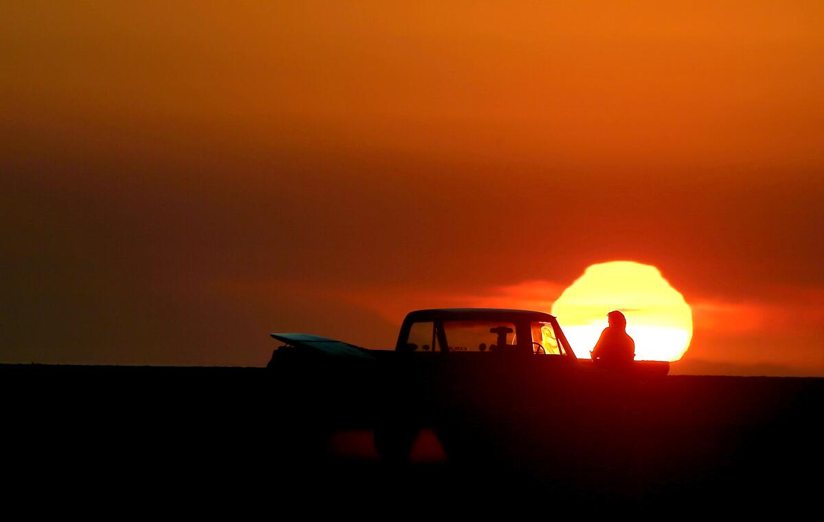 A surfer takes in the sunset at Bolsa Chica State Beach in Huntington Beach on Dec. 2.