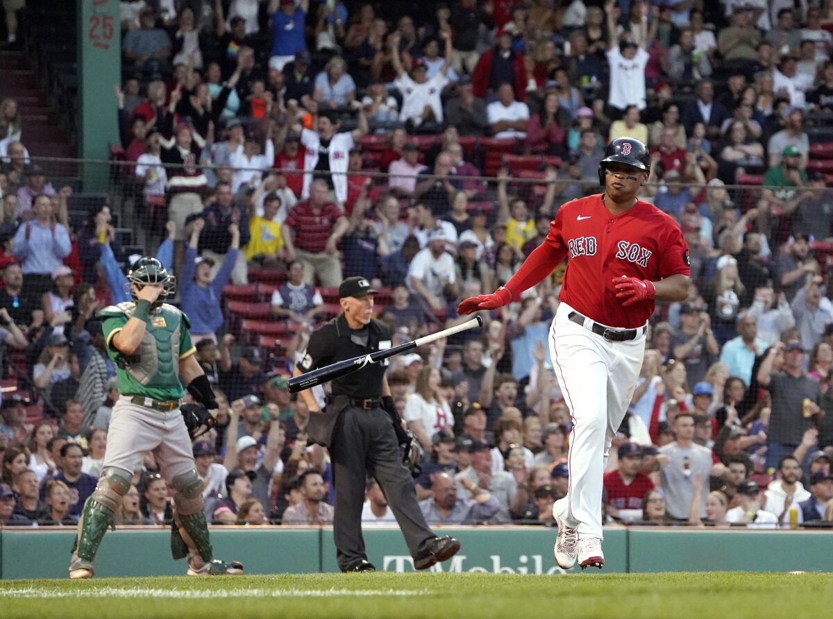 Boston Red Sox's Rafael Devers tosses his bat after hitting a two-run home run, as Oakland Athletics catcher Sean Murphy watches during the second inning of a baseball game at Fenway Park, Wednesday, June 15, 2022, in Boston. (AP Photo/Mary Schwalm)