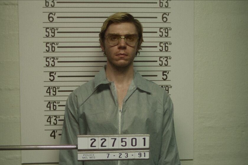 A man with blonde hair in glasses standing in a jail lineup