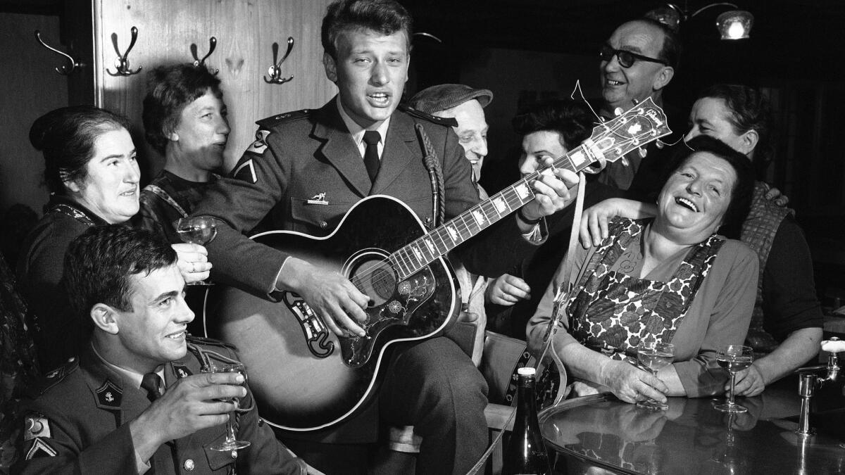 French rock 'n' roll idol Johnny Hallyday plays guitar in Offenburg, Germany, during his military service in 1965.