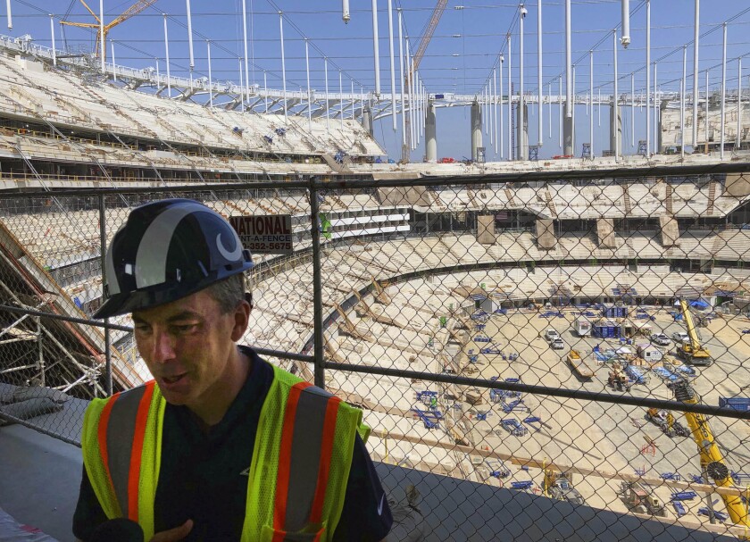 Rams chief operating officer Kevin Demoff speaks to reporters July 30 at the future NFL stadium rising in Inglewood.