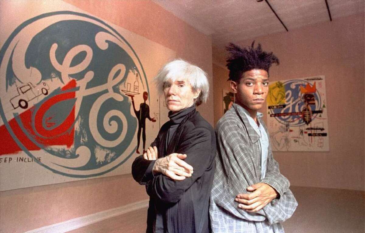 Andy Warhol, left, pictured with Jean-Michel Basquiat in 1985, died two years later. The foundation established in Warhol's will announced that it has finished donating all the pieces he left behind to museums and universities.