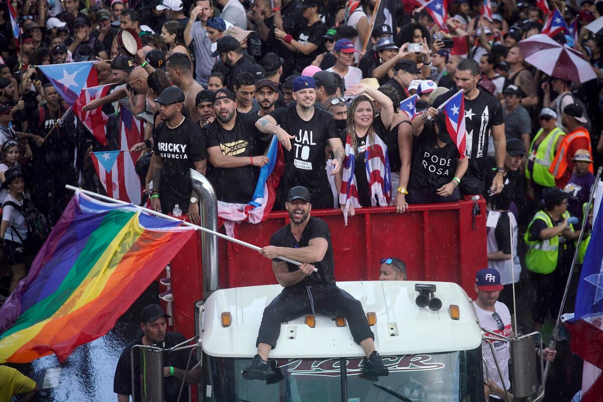 Puerto Rican singer Ricky Martin, center, alongside Puerto Rican rapper Rene Perez, a.k.a. Residente, were among hundreds of thousands who took to the streets of San Juan last month.