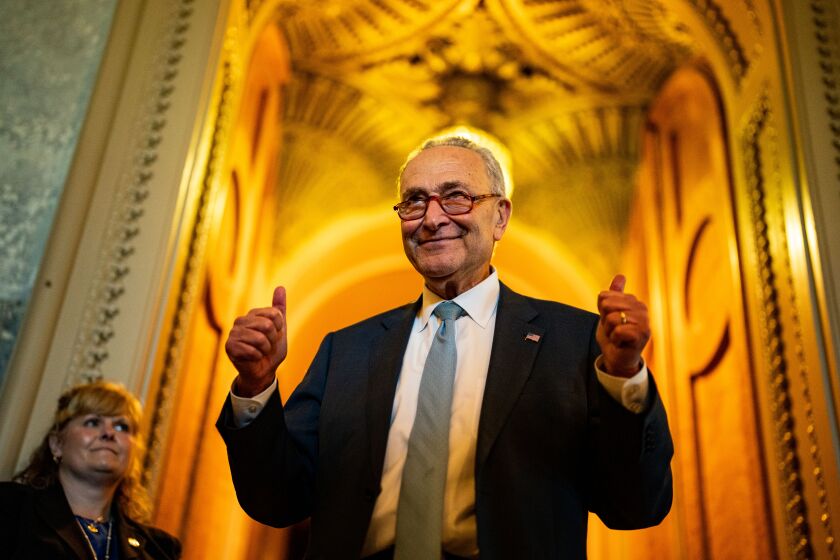 WASHINGTON, DC - AUGUST 07: Senate Majority Leader Chuck Schumer (D-NY) gestures, walking out of the Senate Chamber, celebrating the passage of the Inflation Reduct Act at the U.S. Capitol on Sunday, Aug. 7, 2022 in Washington, DC. The Senate worked overnight Saturday into Sunday as they moved toward final passage of Senate budget reconciliation deal, which Senate Democrats have named The Inflation Reduction Act of 2022. The final vote was 51-50, with the tie-breaking vote being cast by Vice President Kamala Harris. (Kent Nishimura / Los Angeles Times)